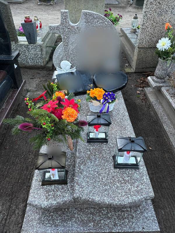 Grób z zimową kompozycją z gwiazdą betlejemską i zapalonymi lampionami
